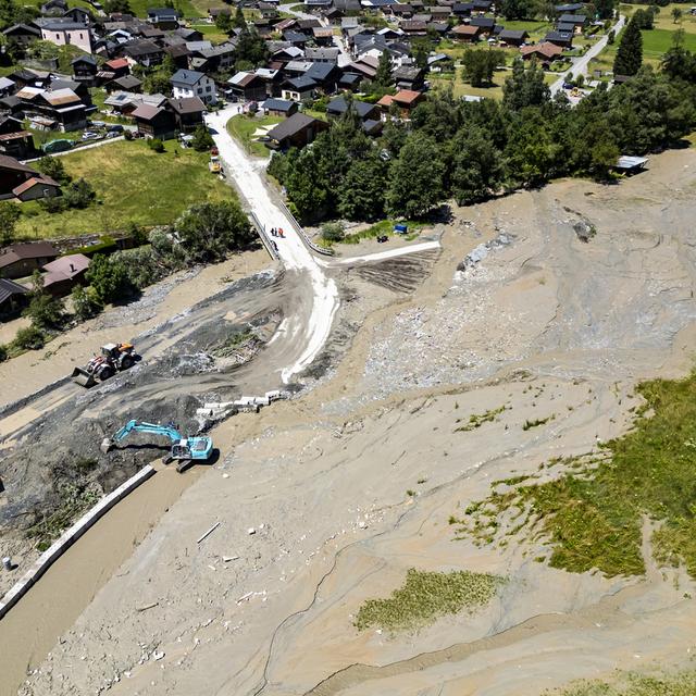 Une vue aérienne montre des ouvriers avec des pelleteuses travaillant sur la coulée de lave torrentielle provenant du torrent du Fregnoley à côté de la rivière la Dranse de Bagnes le jeudi 4 juillet 2024 (image d'illustration). [Keystone - Jean-Christophe Bott]