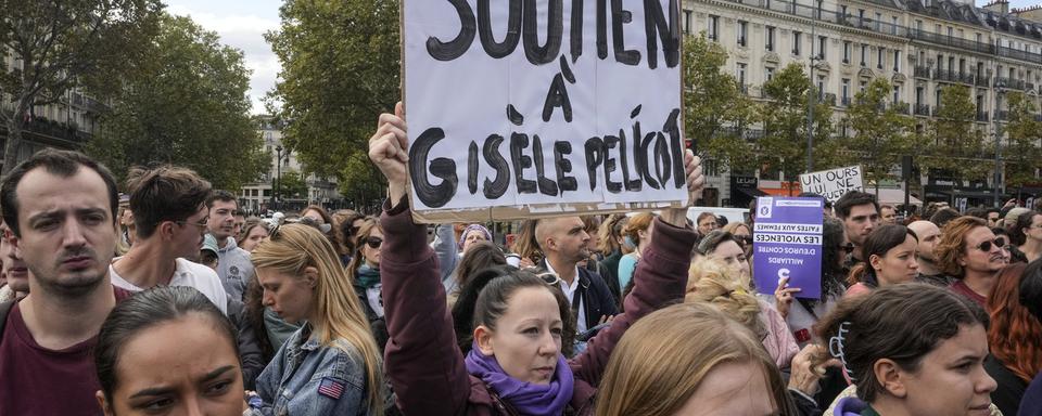 People take part in a gathering in support of 71-year-old Gisele Pelicot who was allegedly drugged by her ex-husband and raped by dozens of men while unconscious, Saturday, Sept. 14, 2024 in Paris. Placard reads, "support for Gisle Pelicot." [AP Photo/Keystone - Michel Euler]