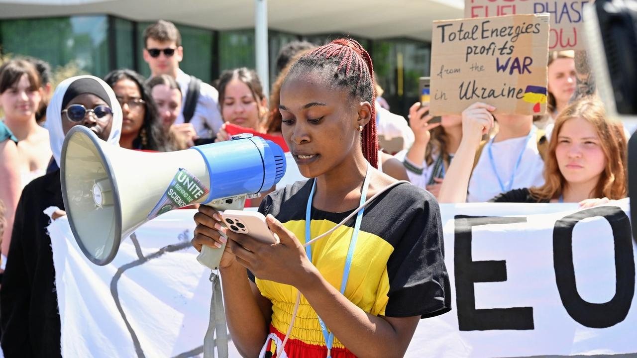 12.06.2023, Nordrhein-Westfalen, Bonn: Patience Nabukalu, Klimaaktivistin aus Uganda, spricht in ein Megafon während einer Demonstration von Fridays for Future gegen eine geplante Öl-Pipeline in Ostafrika. Bei dem von den Klimaschützern kritisierten Projekt soll Öl in einer neuen 1443 Kilometer langen Pipeline vom Westen Ugandas durch Tansania zum Indischen Ozean gebracht werden. Umweltschützer fordern schon länger, das Projekt nicht zu finanzieren. Die Demo geht vom UN-Campus zum Hauptsitz der Postbank. Foto: Henning Kaiser/dpa +++ dpa-Bildfunk +++ (KEYSTONE/DPA/Henning Kaiser) [Keystone/dpa - Henning Kaiser]