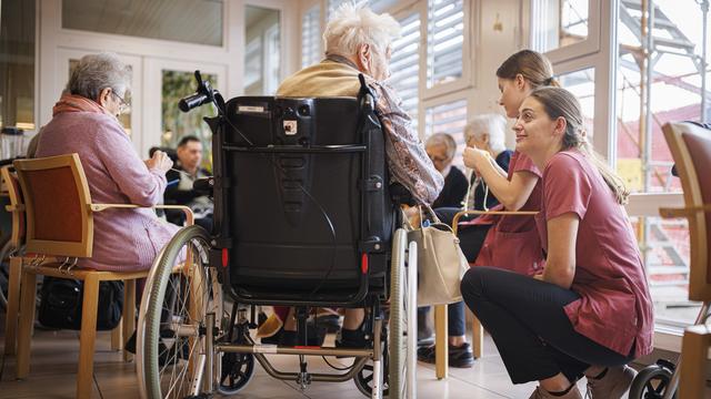 Une membre de l'équipe d'animation assiste une résidente lors d'une activité de tricot le lundi 22 janvier 2024 à l'EMS Saint-Francois à Sion. [Keystone - Valentin Flauraud]