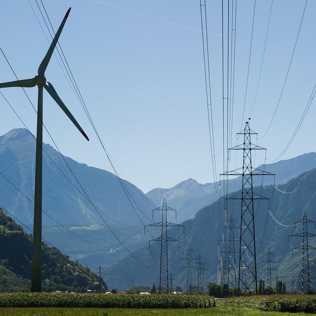 Une éolienne vers un pylone électrique à Collonges (VS). [Keystone - Jean-Christophe Bott]