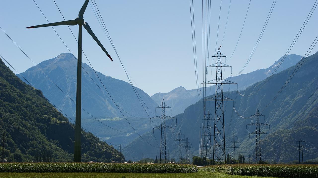 Une éolienne vers un pylone électrique à Collonges (VS). [Keystone - Jean-Christophe Bott]