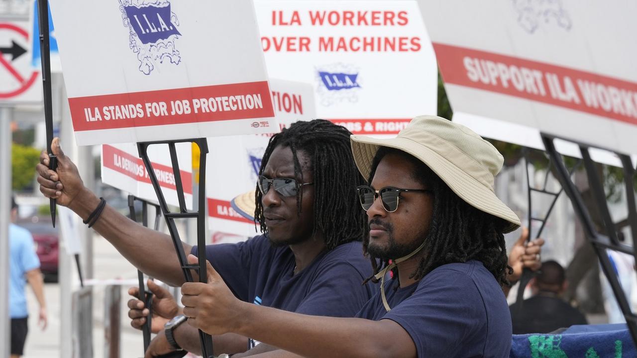 Dockworkers from Port Miami display signs at a picket line, Thursday, Oct. 3, 2024, in Miami. [AP Photo/Keystone - Marta Lavandier]