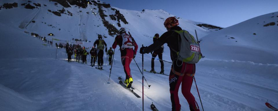 Des concurrents grimpent sur le chemin du col De Riedmatten et du col De Tsena Refien, lors de la 21e course de la Patrouille des Glaciers près d'Arolla, en Suisse, en 2018 (image d'archives). [Keystone - Anthony Anex]