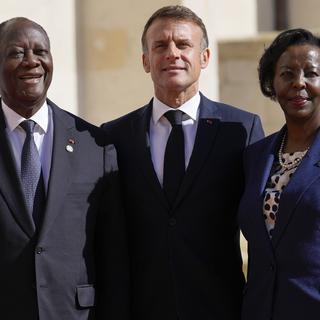 Alassane Ouattara, président de la République de Côte d'Ivoire, est accueilli par le président français Emmanuel Macron et la Secrétaire générale de l'Organisation internationale de la Francophonie Louise Mushikiwabo lors du 19e Sommet de la Francophonie à Villers-Cotteret, en France, le 4 octobre 2024. [KEYSTONE - AURELIEN MORISSARD]