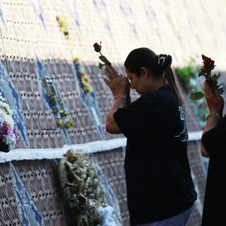 Des proches de victimes du tsunami se recueillent devant le Mémorial dédié à la tragédie. [Keystone/AP - Wason Wanichakorn]