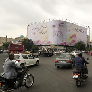 Des véhicules circulent sur la place Enqelab-e-Eslami (Révolution islamique) sous un immense portrait du chef du Hezbollah Hassan Nasrallah, à Téhéran (Iran), le dimanche 29 septembre 2024. [Keystone - AP Photo/Vahid Salemi]