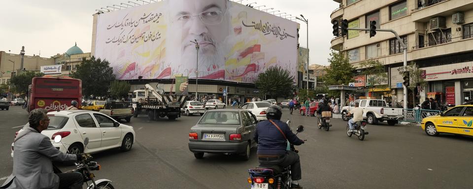 Des véhicules circulent sur la place Enqelab-e-Eslami (Révolution islamique) sous un immense portrait du chef du Hezbollah Hassan Nasrallah, à Téhéran (Iran), le dimanche 29 septembre 2024. [Keystone - AP Photo/Vahid Salemi]