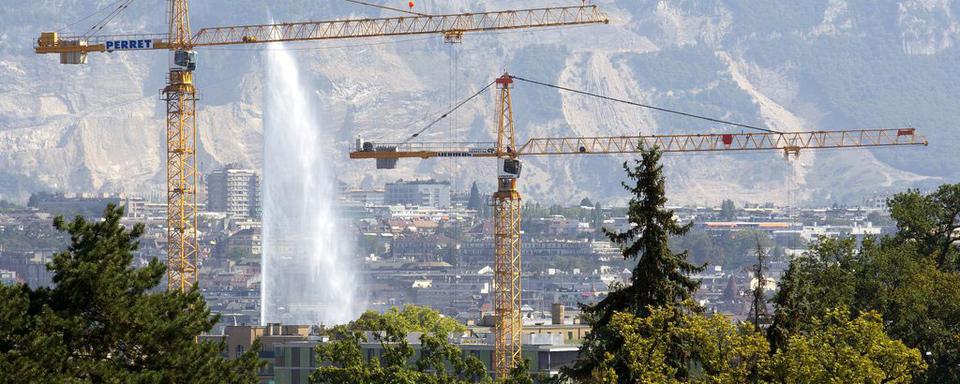 Deux grues qui construisent un immeuble à Genève. [Keystone - Salvatore Di Nolfi]