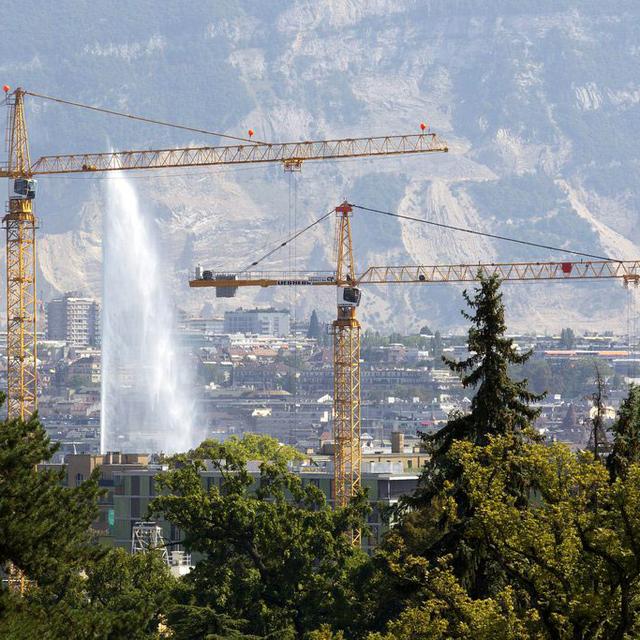Deux grues qui construisent un immeuble à Genève. [Keystone - Salvatore Di Nolfi]