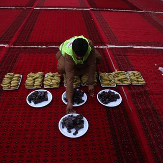 Un homme prépare de la nourriture à l'approche de la rupture du jeune pendant le mois du ramadan. [Keystone - Ghulamullah Habibi]