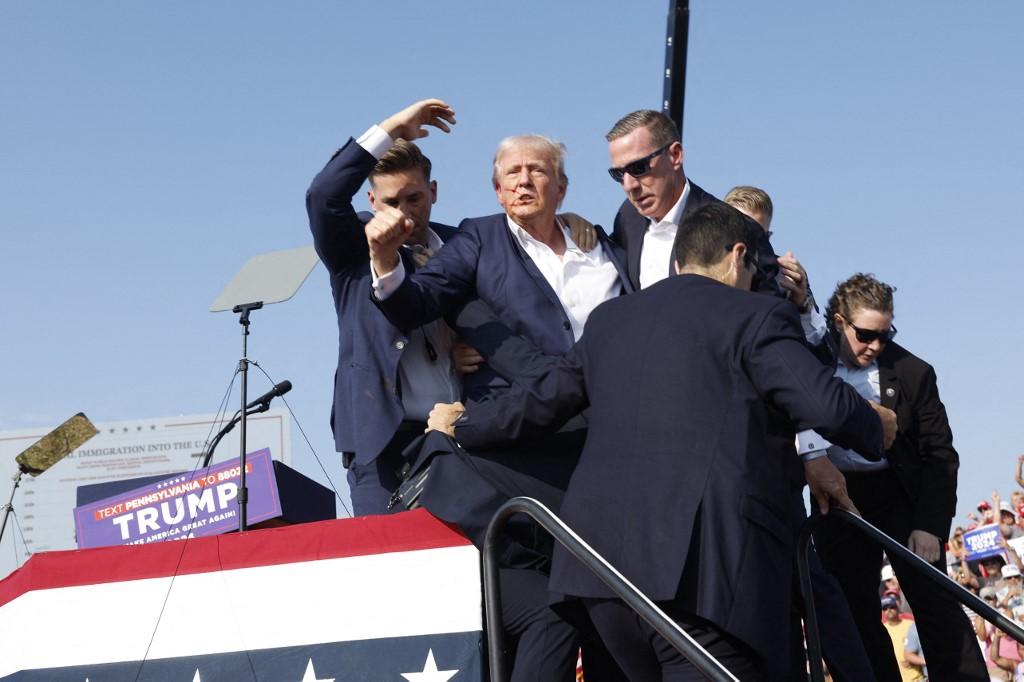 Donald Trump a été escorté par ses gardes du corps de l'estrade à sa voiture. [Getty Images via AFP - ANNA MONEYMAKER]