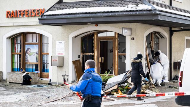 Des membres de la police scientifique de la Gendarmerie vaudoise, inspectent l'explosion du bancomat de la Raiffeisen après un braquage le jeudi 2 février 2023 à Bière. [KEYSTONE - JEAN-CHRISTOPHE BOTT]