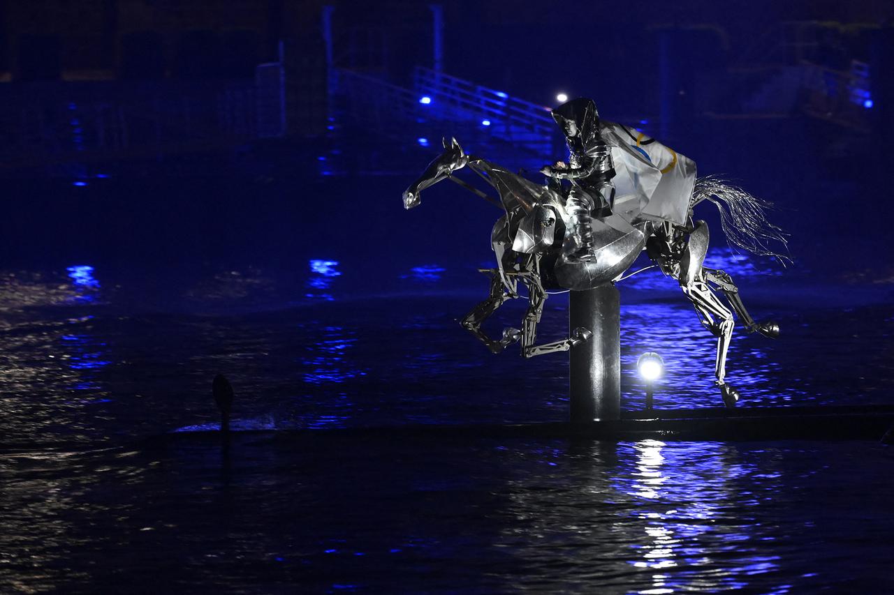 La cavalière mystérieuse sur son destrier mécanique lors de la cérémonie d'ouverture des JO de Paris 2024. [AFP - ARIS MESSINIS]