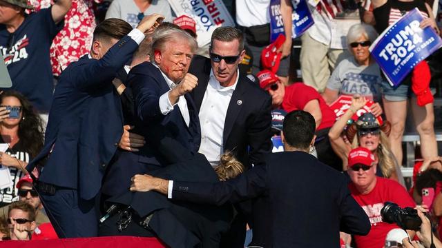 Donald Trump a été escorté sous les acclamations de ses partisans. [AFP - Rebecca DROKE]