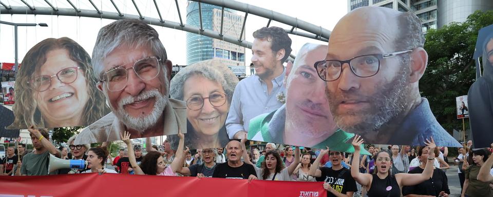 Tel Aviv: des Israéliens manifestent pour pousser leur gouvernement à signer un accord avec le Hamas. [Keystone - EPA/Abir Sultan]