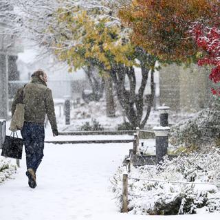 Une personne marche sous la neige à Lausanne (VD), le 21 novembre 2024. [Keystone - Laurent Gillieron]