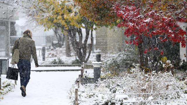 Une personne marche sous la neige à Lausanne (VD), le 21 novembre 2024. [Keystone - Laurent Gillieron]