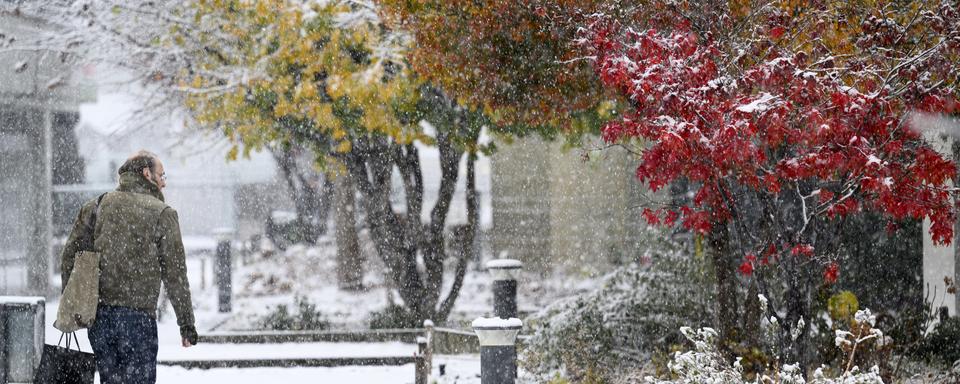 Une personne marche sous la neige à Lausanne (VD), le 21 novembre 2024. [Keystone - Laurent Gillieron]