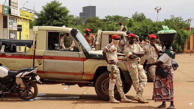 Des militaires de la junte au pouvoir au Niger discutent avec une femme. [KEYSTONE - ISSIFOU DJIBO]