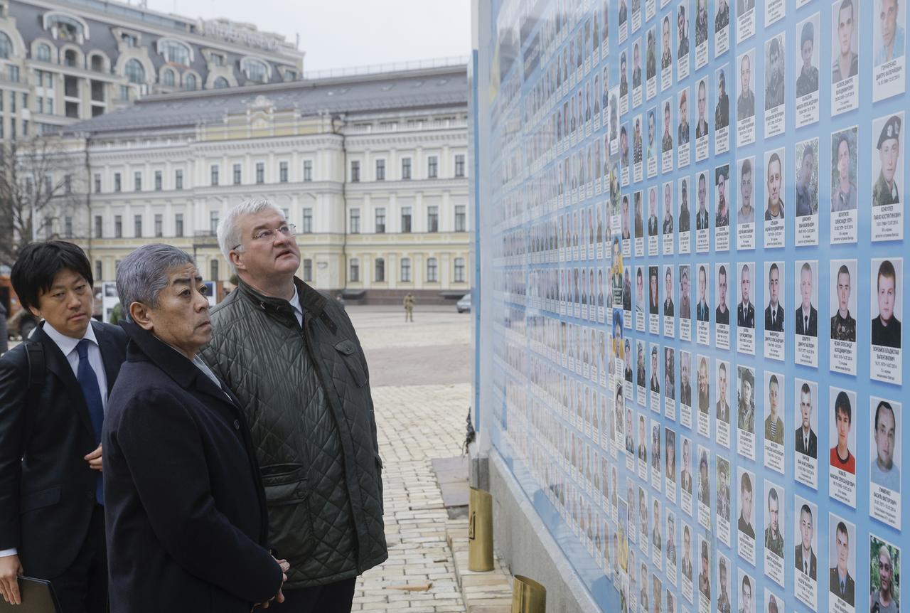 Le ministre japonais des Affaires étrangères Takeshi Iwaya et son homologue ukrainien Andriy Sybiga visitent le mur érigé à la mémoire des défenseurs de l'Ukraine tués au combat, à Kiev. [KEYSTONE - SERGEY DOLZHENKO]