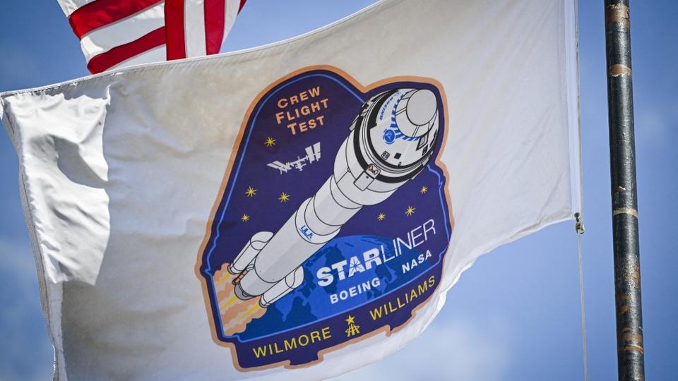 Un drapeau avec le logo de la mission pour le vol d'essai en équipage du Boeing Starliner au Centre spatial Kennedy à Cap Canaveral, Floride, le 3 mai 2024. Les astronautes Butch Wilmore et Suni Williams s'envoleront le 6 mai pour un séjour d'une semaine à bord de la Station spatiale internationale (ISS). [AFP - Miguel J. Rodriguez Carrillo]