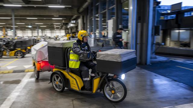 Un employé de La Poste part en tournée le 18 janvier 2024 depuis la base de distribution de Montbrillant (GE). [KEYSTONE - MARTIAL TREZZINI]