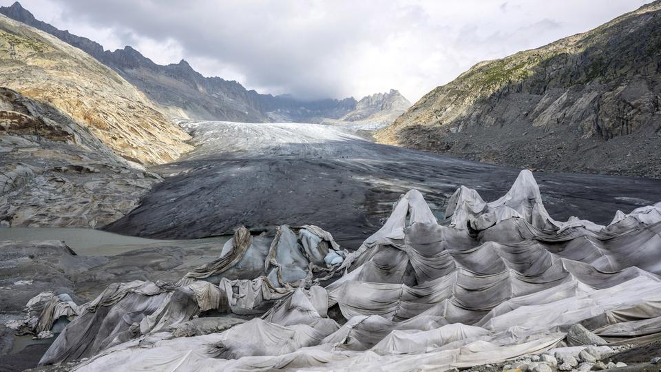 Des couvertures placées sur le glacier du Rhône pour tenter de freiner sa fonte. [KEYSTONE - PETER SCHNEIDER]