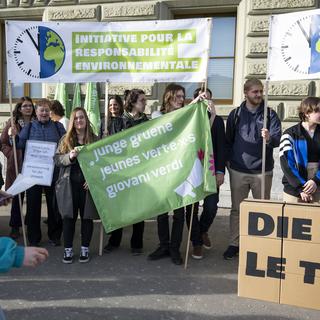 Des membres des Jeunes Verts suisses déposent l'initiative pour la responsabilité environnementale, le mardi 21 février 2023 à Berne. [Keystone - Peter Schneider]