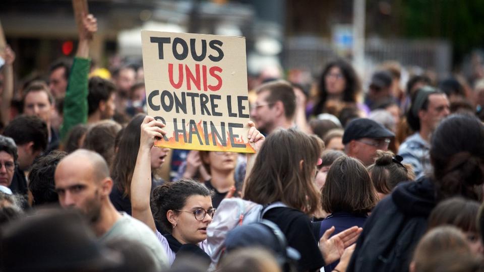 Une manifestante à Toulouse tient une pancarte sur laquelle on peut lire "Tous unis contre le RN". [NurPhoto via AFP - ALAIN PITTON]