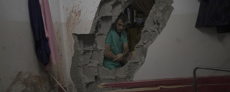 Un médecin palestinien pris dans les ruines de l'hôpital Nasser dans la ville de Khan Younès, au sud de Gaza. [Keystone/EPA - Haitham Imad]