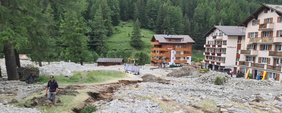 A Saas-Grund (VS), la route cantonale a été déblayée, mais des tas de matériaux mélangés à de la boue recouvrent encore les trottoirs, le 2 juillet 2024. [RTS - EMILIEN VERDON]