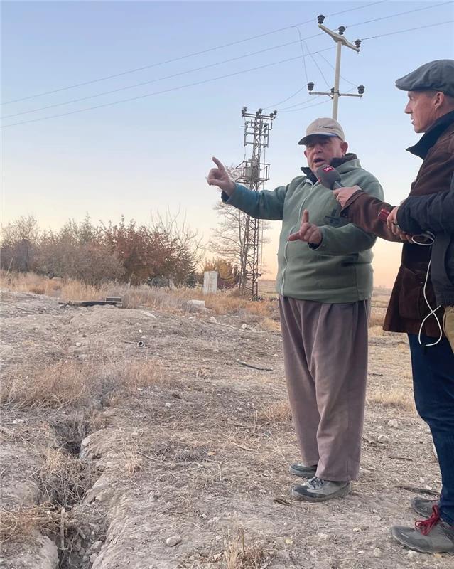 Le fermier Adem Ekmekçi devant un trou dans le sol. Là où il y a un enfoncement et où des fissures d’un mètre de long apparaissent, le sol pourrait bientôt s’effondrer. [SRF - Christian von Burg]