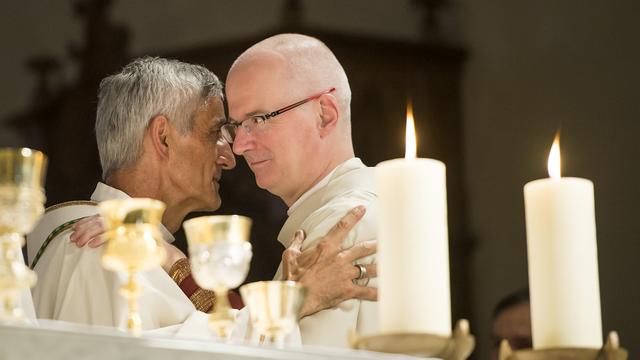 Le nouvel eveque de Sion, Mgr Jean-Marie Lovey, gauche, parle avec Charles Morerod, eveque de Lausanne, Geneve et Fribourg, droite, lors de l'ordination episcopale du nouvel eveque ce dimanche 28 septembre 2014 dans la cathedrale de Sion. (KEYSTONE/) [Keystone - Jean-Christophe Bott]