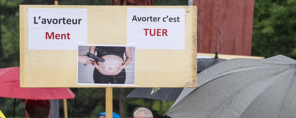 Des personnes manifestent lors d'un rassemblement anti-avortement, ce samedi 3 juillet 2021 sur la Place des Nations face a l'ONU a Geneve. Les manifestants ont reciter un chapelet et manifester leur attachement a la vie, l'avortement n'est pas une question de libre choix de la femme, c'est une question de vie ou de mort et ainsi protester contre le Parlement europeen qui a adopte une resolution appelant les Etats membres a l'egaliser l'avortement. [Keystone - Martial Trezzini]