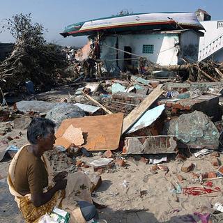 Une femme assise devant sa maison détruite après le passage du tsunami le 26 décembre 2004 à Nagattinam, Tamil Nadu, en Inde. [EPA/KEYSTONE - HARISH TYAGI]