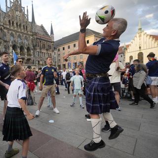Des fans de l'équipe écossaise de football font la fête à Munich avant l'Euro 2024. [Keystone/AP Photo - Antonio Calanni]