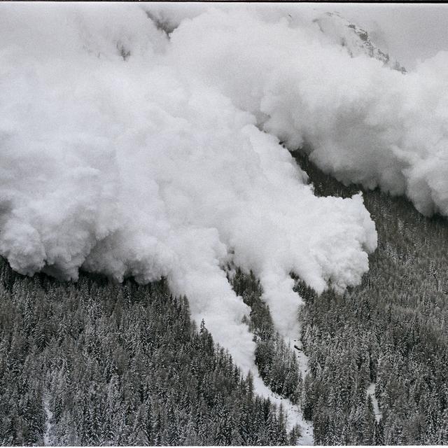 Une puissante avalanche de neige déferle dans la vallée d'Evolène dans les Alpes suisses le 22 février 1999, un jour après qu'une avalanche à Evolène ait fait 12 morts. [Keystone - Fabrice Coffrini]