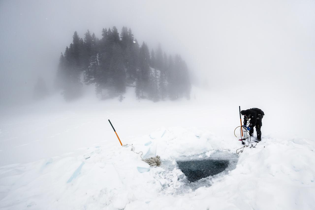 Un plongeur se prépare à entrer sous la glace du lac Loison. [KEYSTONE - VALENTIN FLAURAUD]