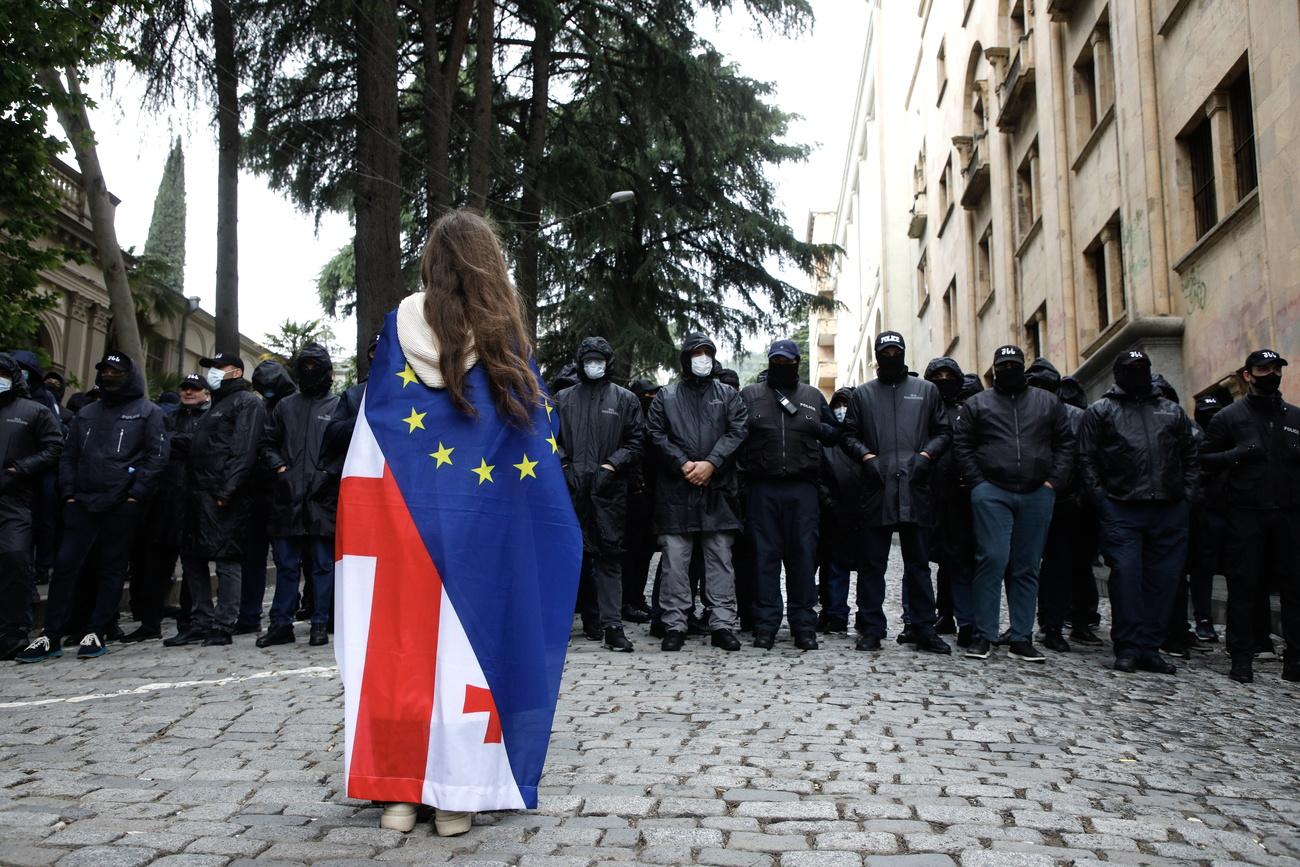Une manifestante pro-européenne fait face à la police, à Tbilissi, la capitale géorgienne, le 14 mai 2024. [KEYSTONE - DAVID MDZINARISHVILI]