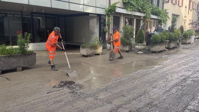 Des ouvriers nettoient la boue laissée par les inondations à Morges le 26 juin 2024. [Ville de Morges]