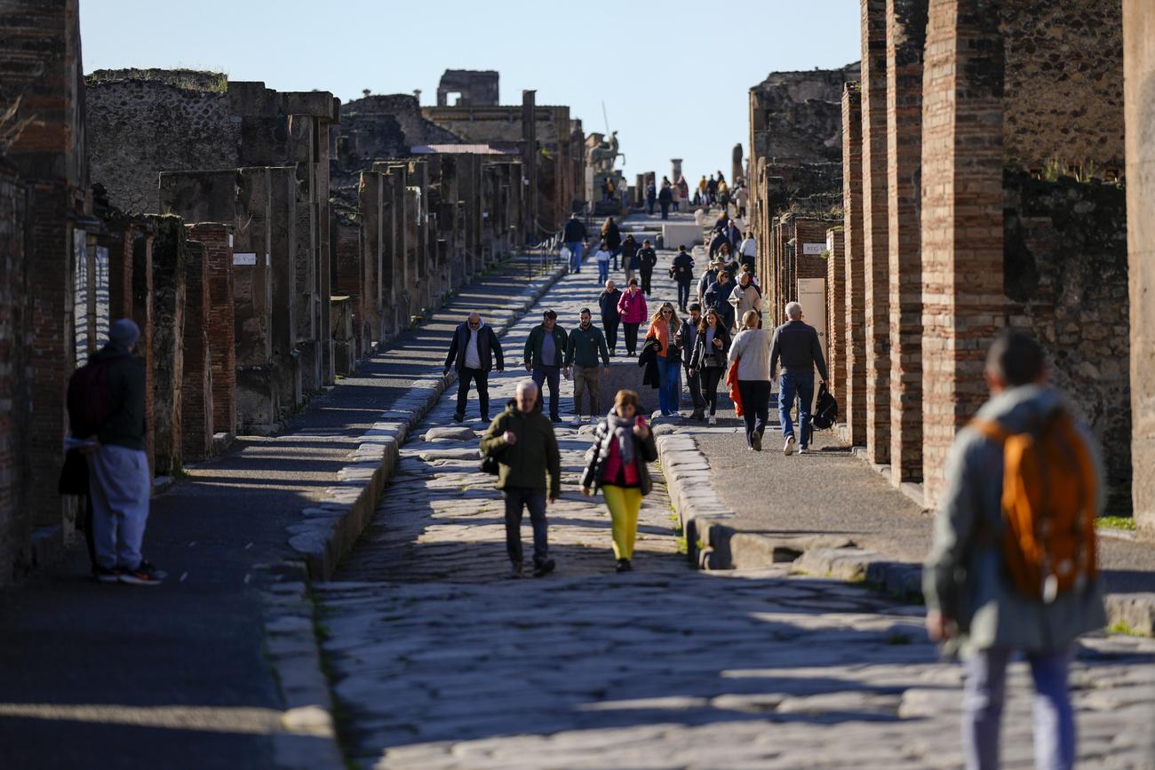 Des visiteurs descendent une ancienne rue romaine du site archéologique de Pompéi, [KEYSTONE - ANDREW MEDICHINI]