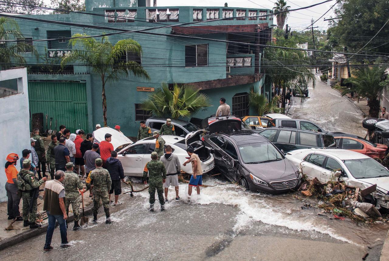 Des membres de l'armée mexicaine nettoient une rue après des inondations dues à de fortes pluies à Guadalupe, dans l'État de Nuevo León, au Mexique, le 17 octobre 2024. [AFP - JULIO CESAR AGUILAR]