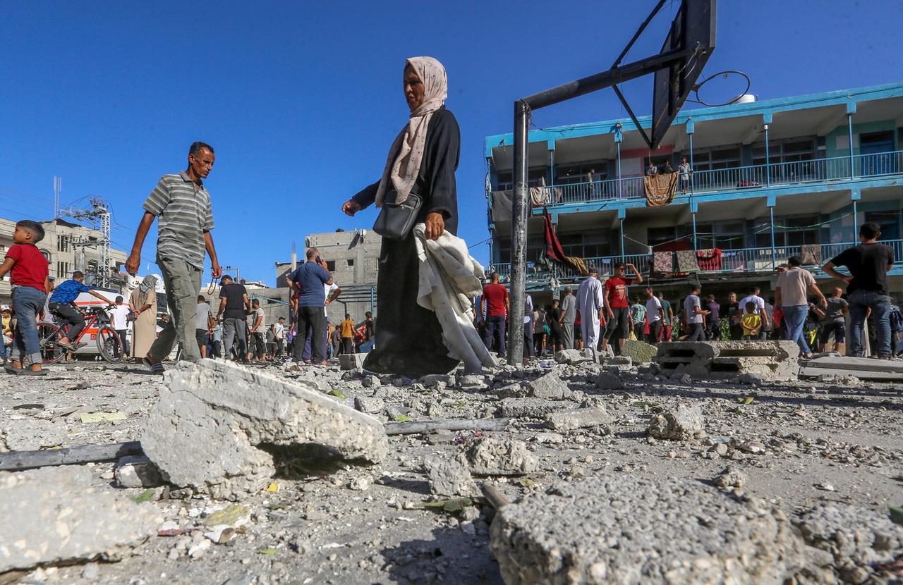 Des Palestiniens inspectent les décombres d'une école gérée par l'UNRWA, une école transformée en abri connue sous le nom d'al-Jaouni, après une frappe aérienne israélienne dans le camp de réfugiés d'Al-Nuseirat, au centre de la bande de Gaza, le 11 septembre 2024. [KEYSTONE - MOHAMMED SABER]