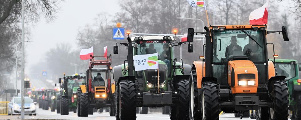 Les agriculteurs polonais conduisent leurs tracteurs lors d'une manifestation à Zbuczyn, dans le centre de la Pologne, le 24 janvier 2024. [keystone - Przemyslaw Piatkowski]