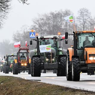 Les agriculteurs polonais conduisent leurs tracteurs lors d'une manifestation à Zbuczyn, dans le centre de la Pologne, le 24 janvier 2024. [keystone - Przemyslaw Piatkowski]