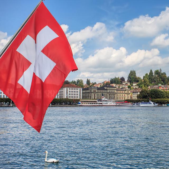 Un drapeau Suisse en ville (Lucerne). [Depositphotos - © Photogearch]