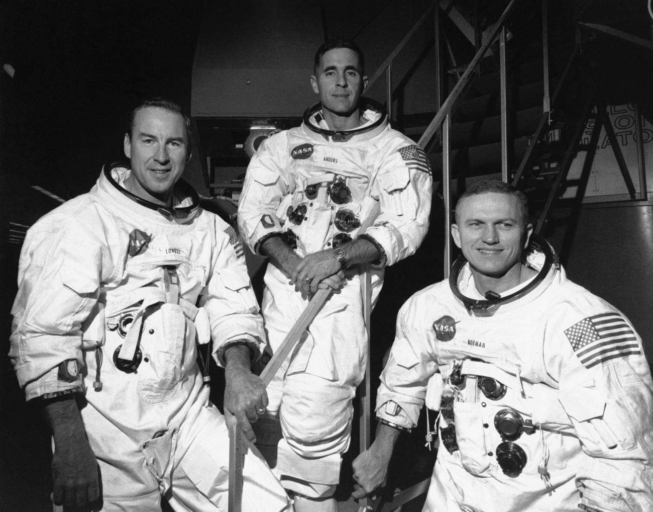 L'équipage d'Apollo 8, le 18 décembre 1968, devant le simulateur de mission au Centre spatial Kennedy, en Floride, avant de s'entraîner en vue de sa mission orbitale lunaire de six jours. De gauche à droite, James Lovell, pilote du module de commande, William Anders, pilote du module lunaire, et Frank Borman, commandant. [KEYSTONE]