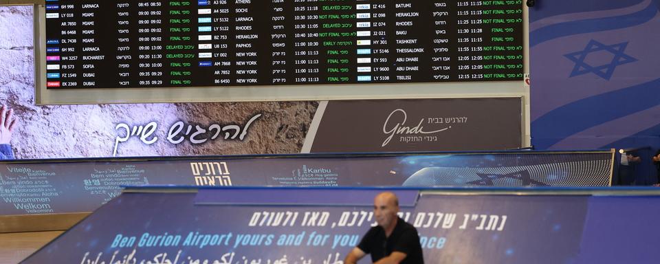 Un homme est assis sous le tableau des horaires de vol à l'aéroport international Ben Gourion après que le syndicaliste israélien et président de la Histadrut, Arnon Bar-David, a annoncé une grève générale; à Tel Aviv, Israël, le 2 septembre 2024. [CLÉ DE VOÛTE - ABIR SULTAN]