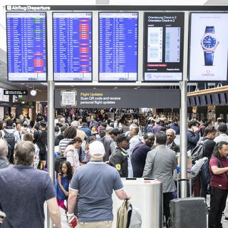 Des passagers attendant leur vol à l'aéroport de Genève. [Keystone - Ennio Leanza]